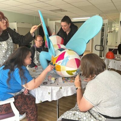 ECL customers painting a large bee sculpture