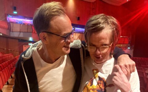 Jason and his fan hugging and looking at the camera