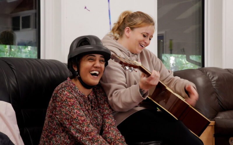 Chloe playing guitar and putting on the show for ECL customers