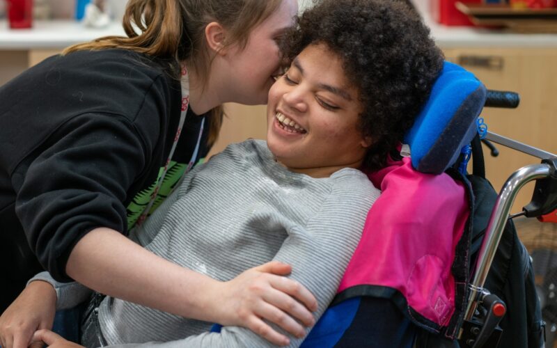 Carer giving support to customer in a wheelchair