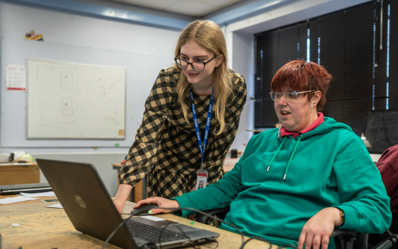 Carer helping women to use a laptop