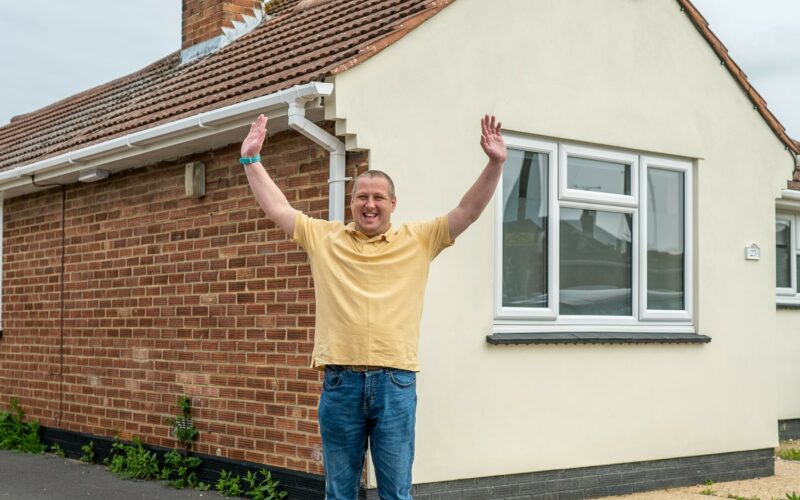 Man happy outside house