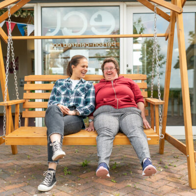 Carer and women laughing on a swing