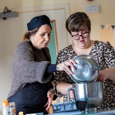 Young lady with mild learning disabilities volunteering in a community cafe