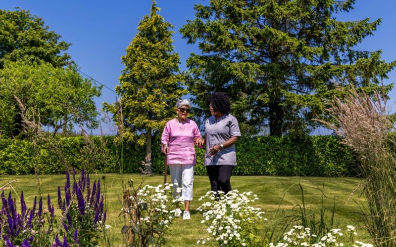 ECL customer and Community Care Assistant wandering in the garden