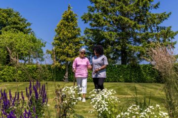 ECL customer and Community Care Assistant wandering in the garden