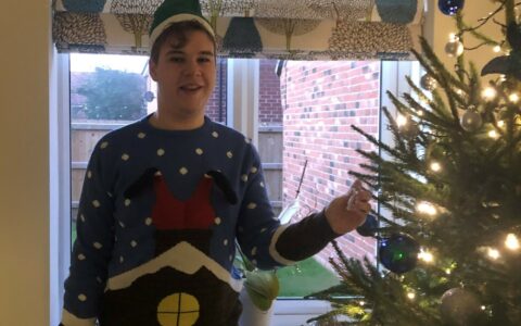Lynden is his Christmas jumper decorating his family home's Christmas tree.