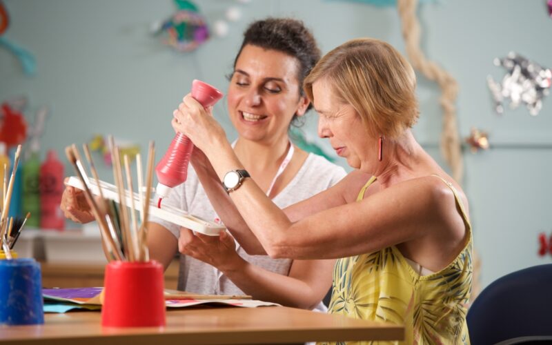 Carer and customer painting together