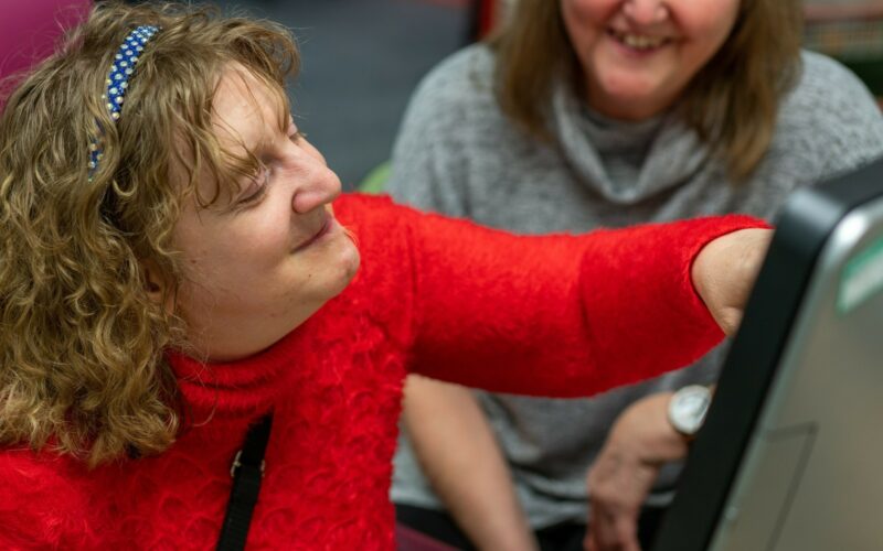 Carer helping customer on a computer