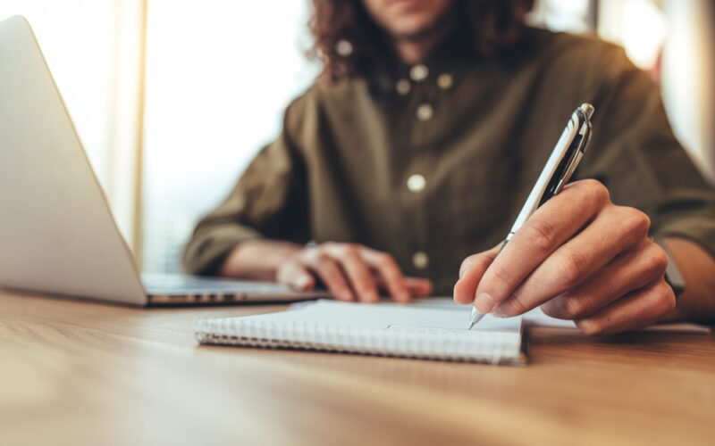 Person writing notes down on a notepad