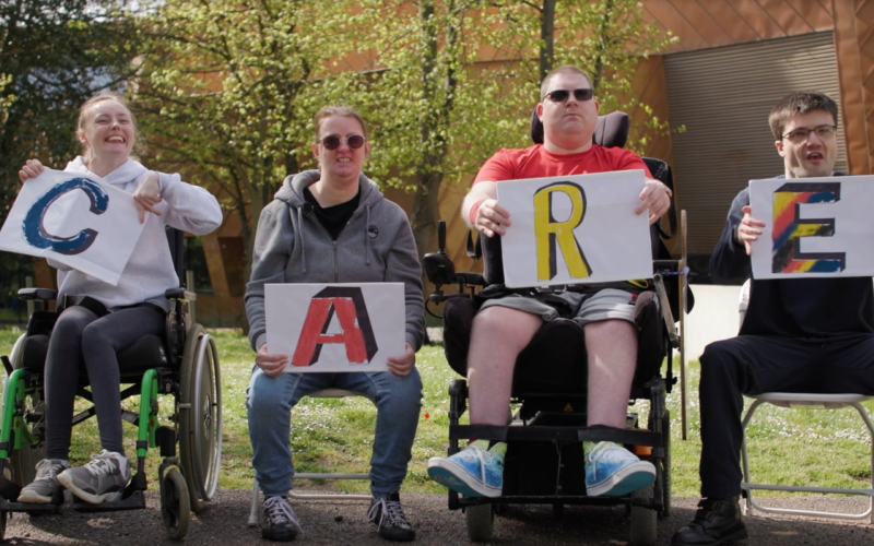 People with learning disabilities spelling out the word CARE using letters
