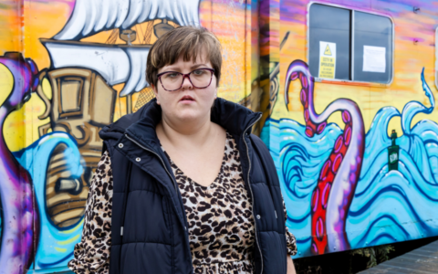 Melanie in front of a ocean themed painted wall